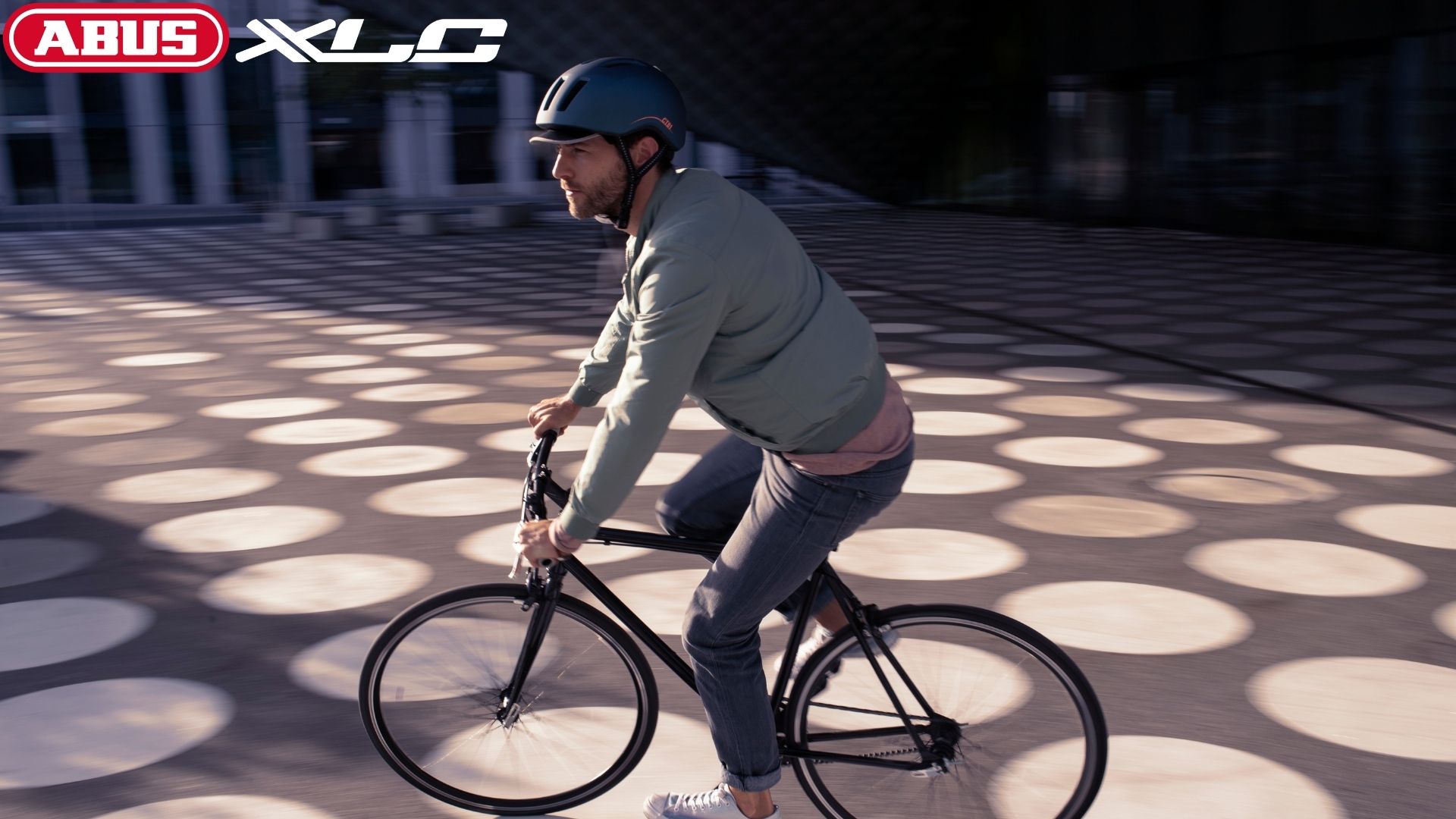Rowerzysta ubrany w kask rowerowy na tle placu w mieście